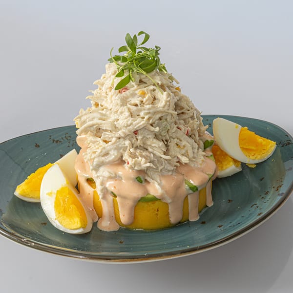 Bocas House's Causa de Pollo, a Peruvian dish with mashed yellow potato, shredded chicken, and sliced eggs.