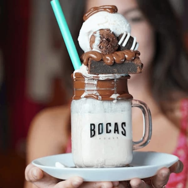 A Bocas House milkshake in a mason jar, topped with ice cream, brownie, and chocolate drizzle.