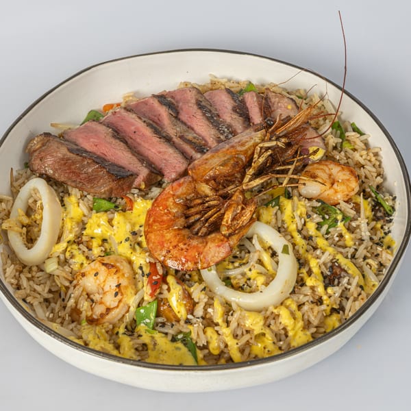 Bocas House's Latin-American fried rice with sliced steak, shrimp, squid, and yellow sauce.
