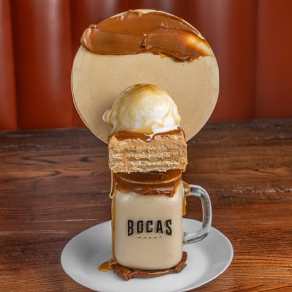 Bocas House milkshake with dulce de leche, ice cream, and a large wafer cookie on a white plate.