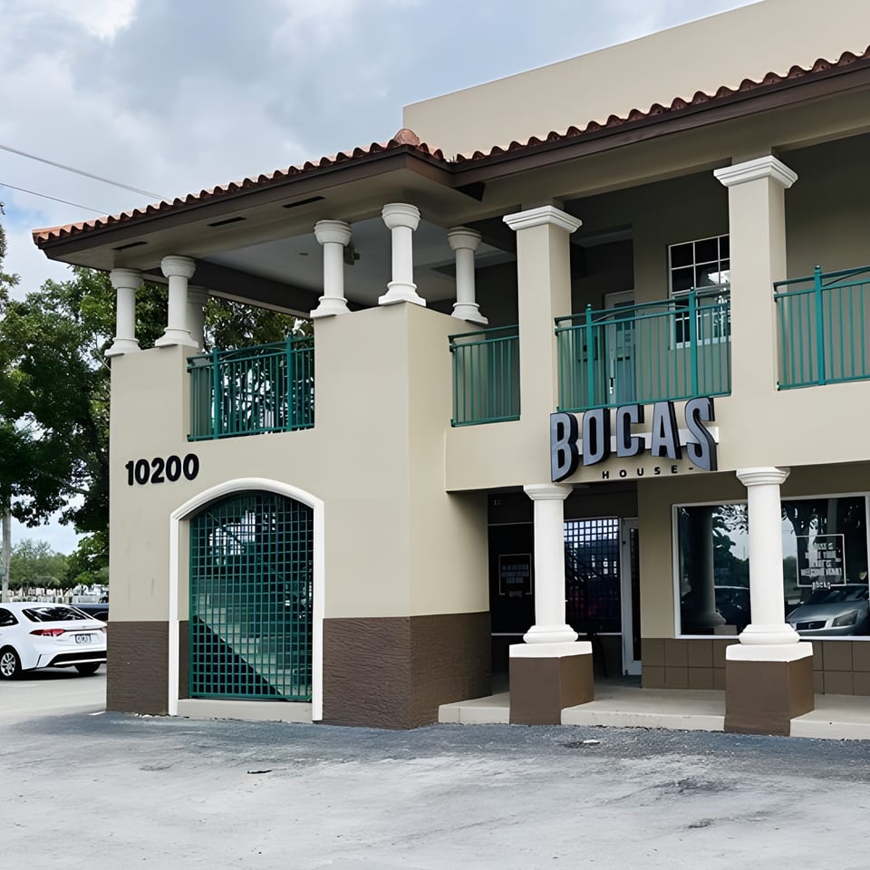 Exterior of Bocas House, a two-story building with columns, teal railings, and a prominent sign.