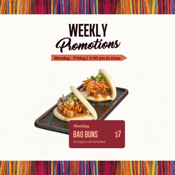 Two Bao Buns with meat, shredded carrots, and green onions on a black rectangular plate.