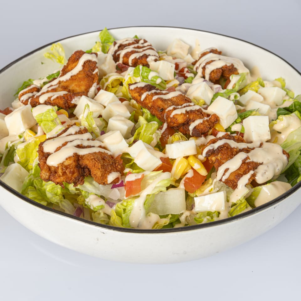 Bocas House salad with fried chicken, cheese cubes, corn, tomatoes, and creamy dressing.