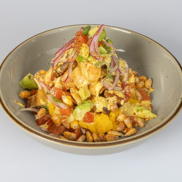 Bocas House's Latin American dish with red onions, avocado, corn, and a creamy yellow sauce.